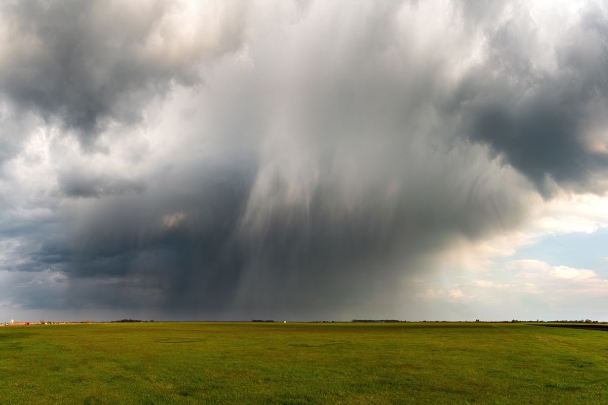 Storm clouds over open countryside, when a battery backup sump pump keeps working through a power cut
