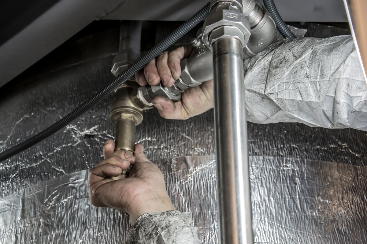 Plumber checking pipe fittings for air in well water lines